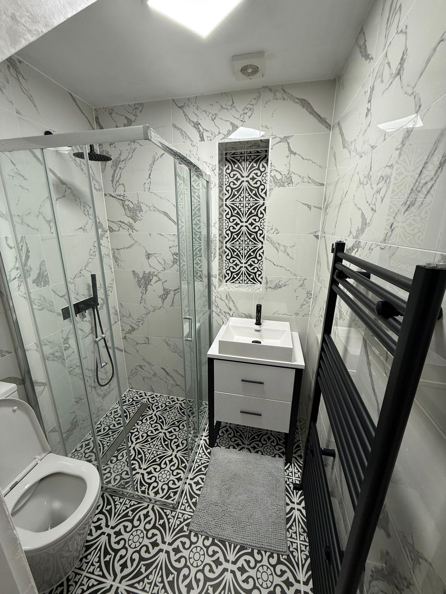 New marble-effect shower room with patterned floor