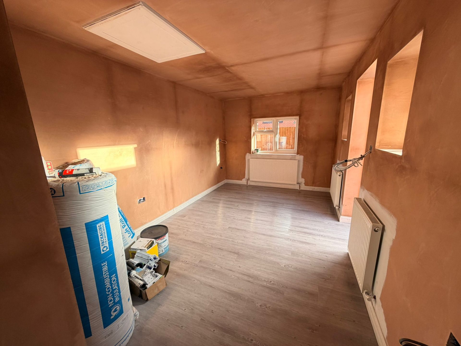 Living room with bare plaster walls before decorating