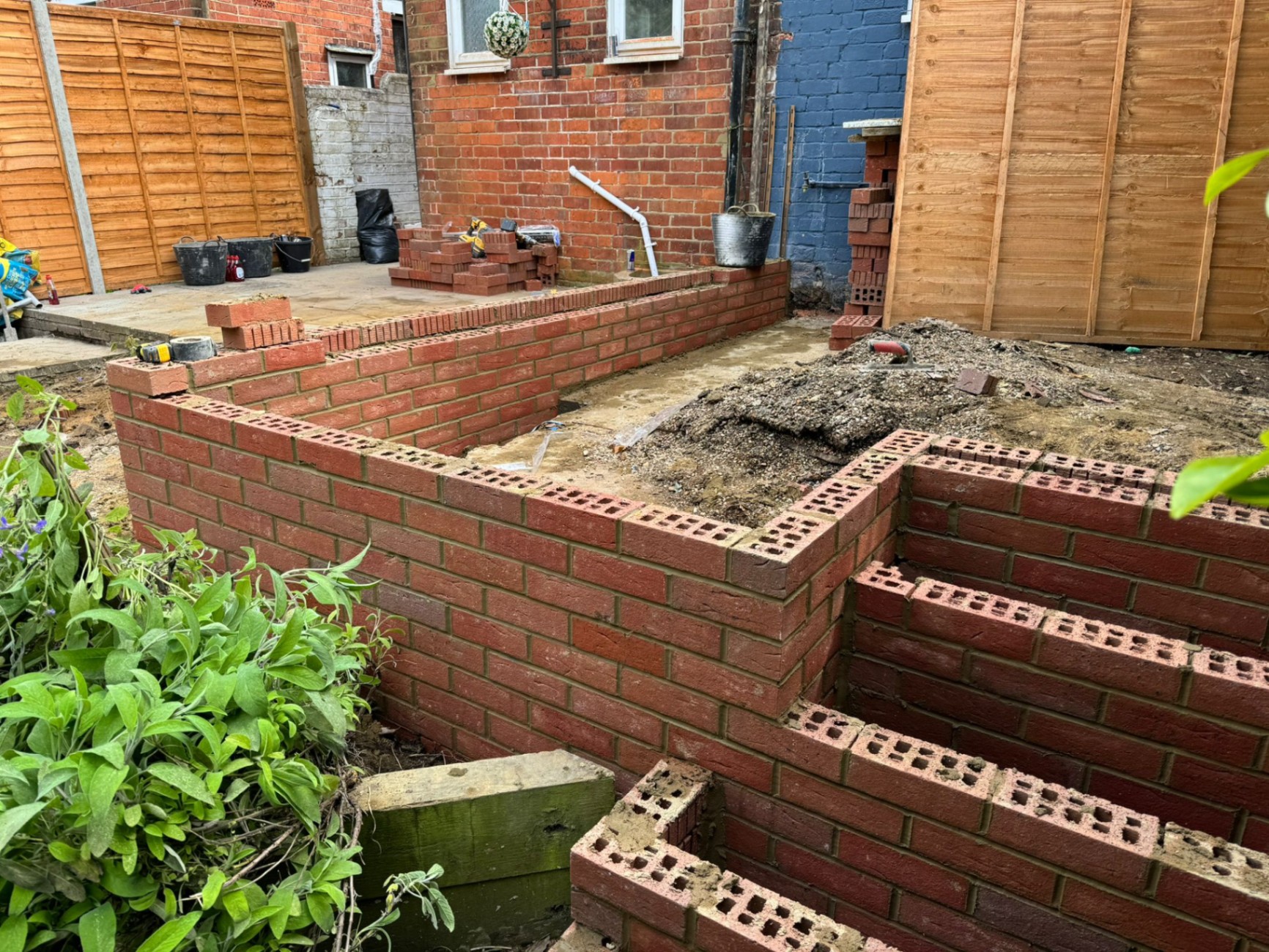Tiered brick retaining walls under construction in rear garden